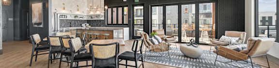 A modern living room with black chairs and a wooden floor.