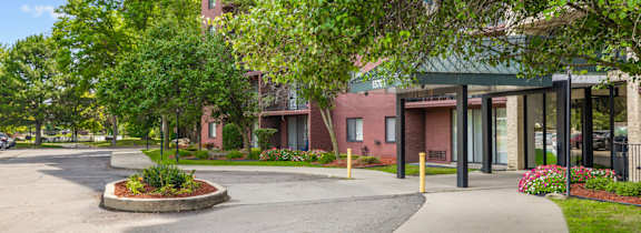 A building with a green roof and a parking lot in front.