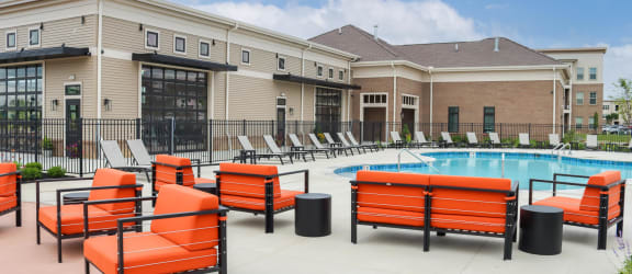 a group of orange lounge chairs next to a swimming pool