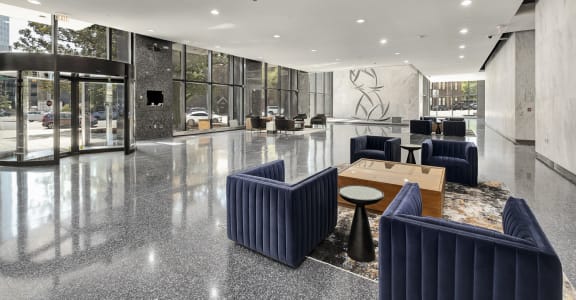 a large lobby with blue chairs and a table  at The 600 Apartments, Alabama, 35203