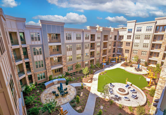 an aerial view of an apartment complex with a playground and fountain