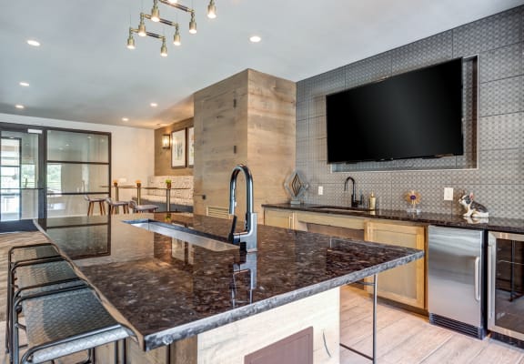 a large kitchen with granite countertops and a large tv on the wall