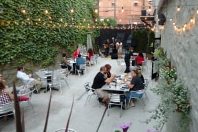 a group of people sitting at tables in a patio