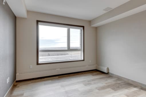 the living room of an empty apartment with a large window