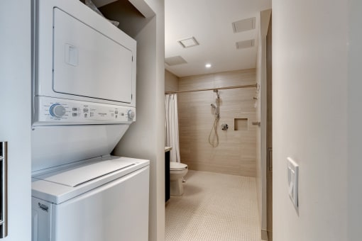 a laundry room with a washer and dryer and a bathroom with a shower