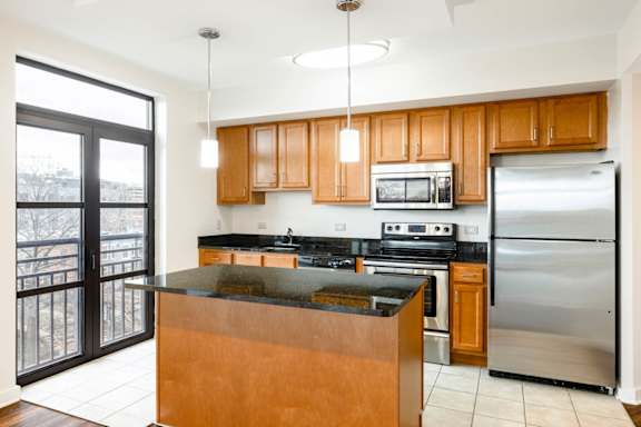 A kitchen with wooden cabinets and a black counter top. at Loree Grand at Union Place, Washington