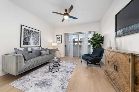 a living room with a couch and a ceiling fan