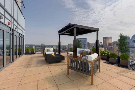 a rooftop terrace with furniture and a gazebo and a city skyline at Versus, Calgary, Alberta, T2R 1A8