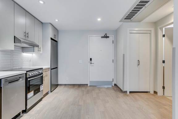 a renovated kitchen with white cabinets and stainless steel appliances