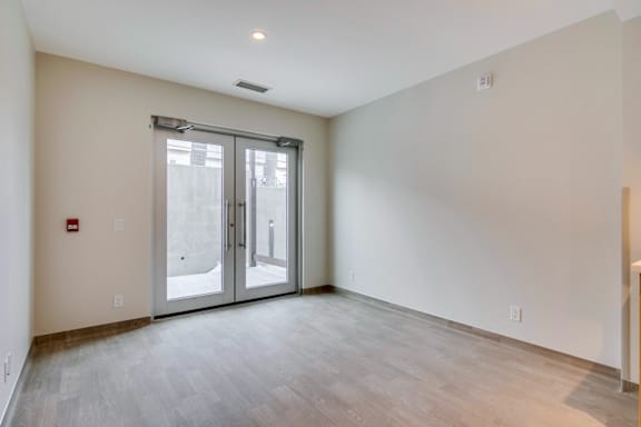 an empty living room with white walls and glass doors