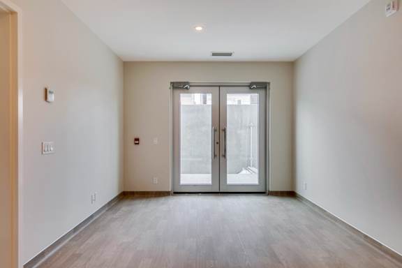 an empty living room with white walls and a sliding glass door