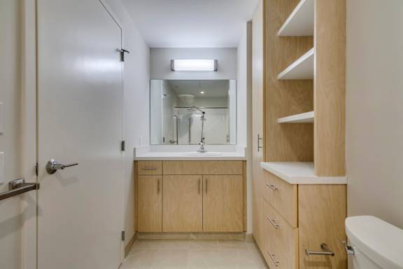 a bathroom with wooden cabinets and a sink and a mirror