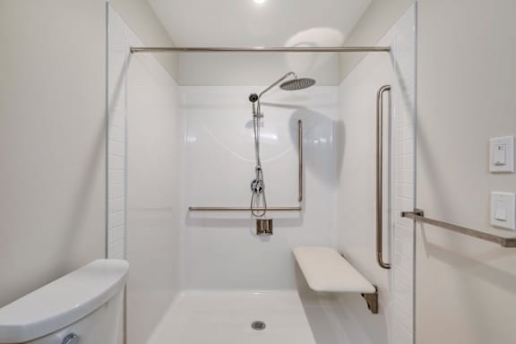 a white bathroom with a shower and a toilet