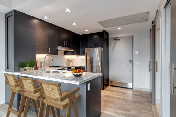 a kitchen with a marble counter top and wooden bar stools