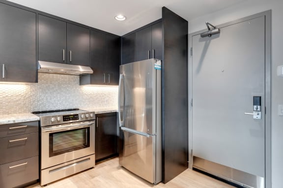 a kitchen with stainless steel appliances and black cabinets
