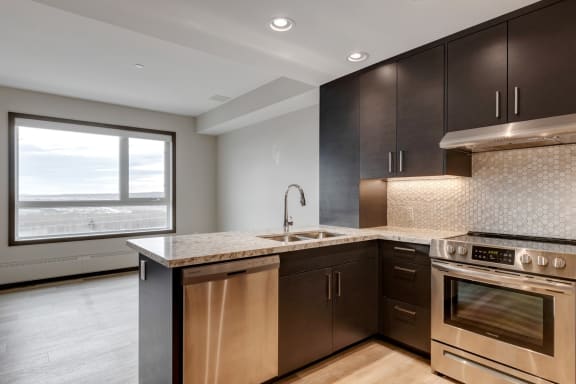 an empty kitchen with wooden cabinets and stainless steel appliances