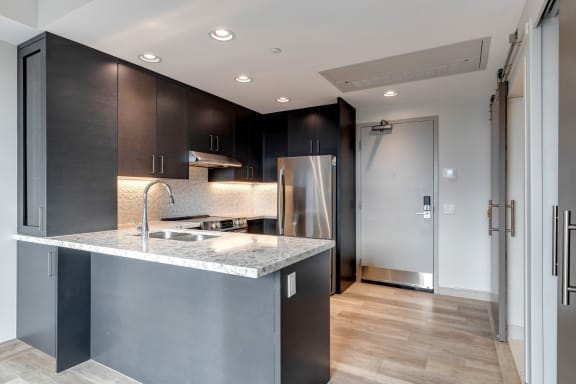 a kitchen with stainless steel appliances and a marble counter top