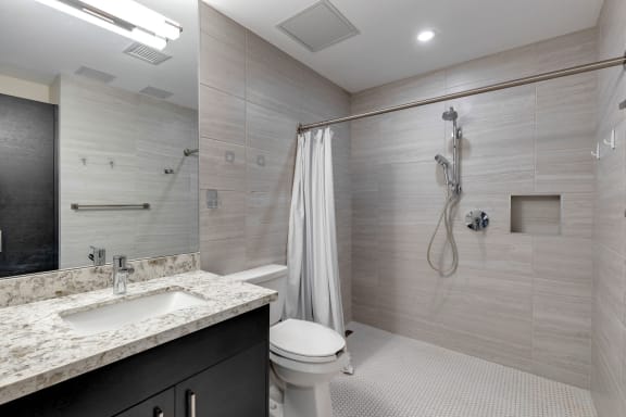 a bathroom with a shower and a sink and a toilet