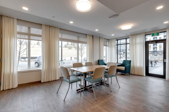 a conference room with a table and chairs and large windows