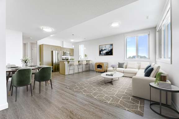 A modern living room with a dining area and a kitchen in the background.