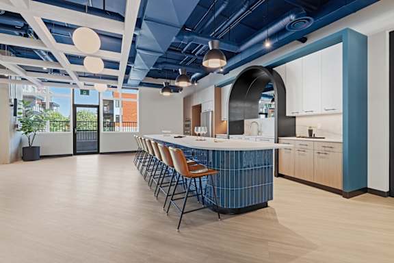 A modern kitchen with a long island and chairs.