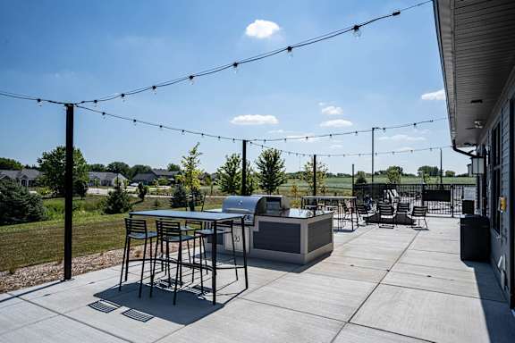a patio with tables and chairs and a grill at Tivoli Green Apartments & Townhomes, Mount Pleasant