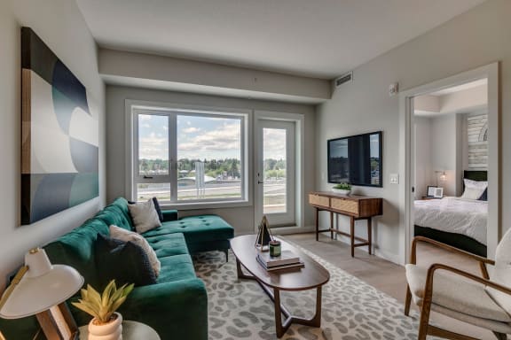 a living room with a green couch and a flat screen tv