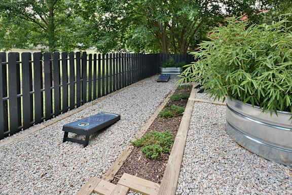 a garden with gravel and plants and a black fence at Capital Flats & Magnolia Square Apartments, Raleigh, 27601
