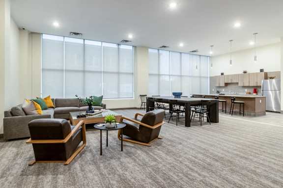 A modern living room with a grey carpet and furniture.