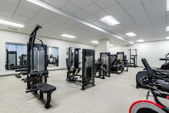 A gym with a variety of equipment including a stationary bike.
