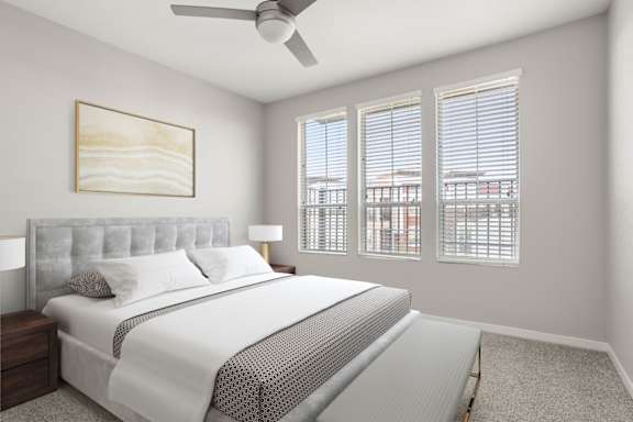 A bedroom with a large bed and a ceiling fan.