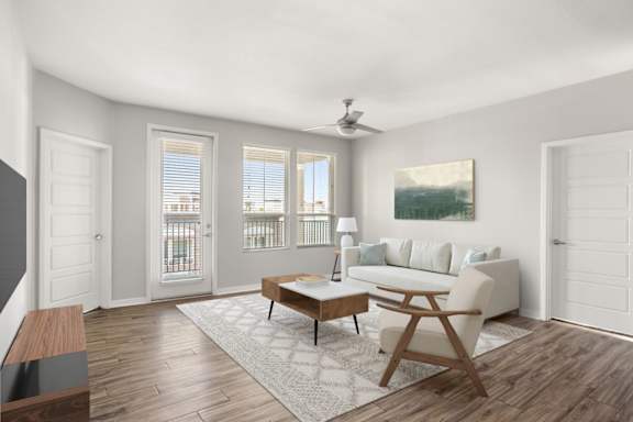 A living room with a white couch, a wooden coffee table, and a painting on the wall.