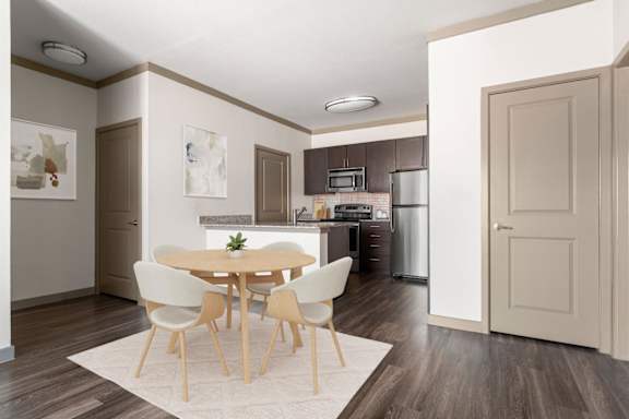 A kitchen with a table and chairs in the middle of the room.