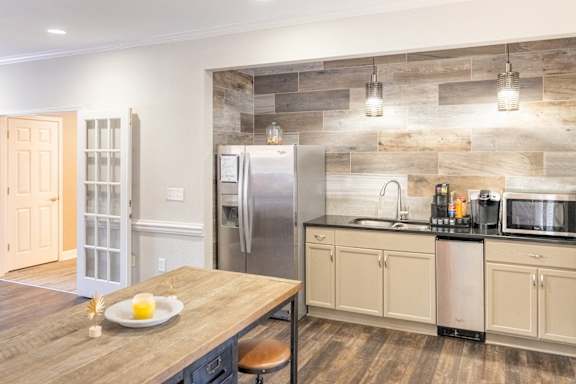 A kitchen with a wooden table and a refrigerator.