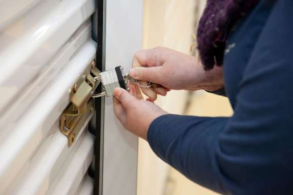 A person is installing a lock on a white door.