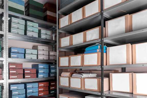 A shelf with various boxes and containers.