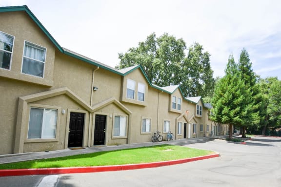 a row of townhomes with a yard in front of them