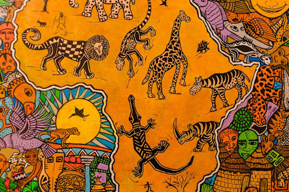 a close up of an orange cloth with various animals on it