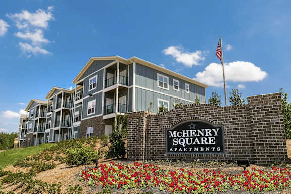 A McHenry Square Apartments sign is in front of a building.