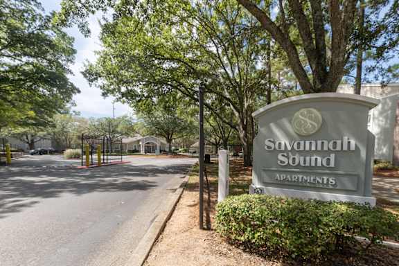 Savannah Sound Apartments sign in front of a tree.