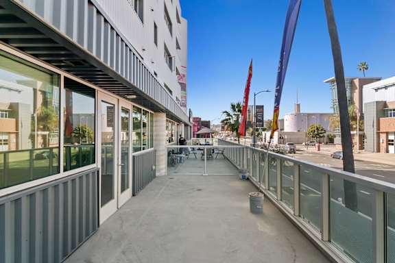 A long concrete walkway with glass railings on both sides in a live/work apartment at Fusion Hollywood.