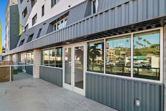 A modern building with a grey facade and large windows in a live/work apartment at Fusion Hollywood.