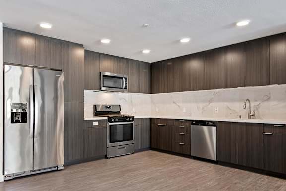 A modern kitchen with stainless steel appliances and wooden cabinets at Fusion Hollywood.