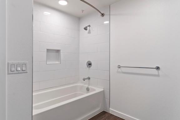 A white bathroom with a tub and a shower at Fusion Hollywood.