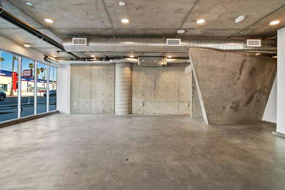 A large empty room with concrete walls and floor in a live/work loft apartment at Fusion Hollywood.