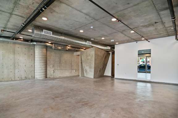 A large empty room with concrete walls and ceiling in a live/work space apartment at Fusion Hollywood.