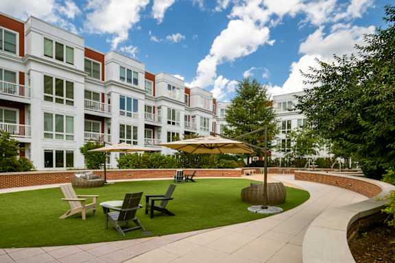 A large apartment complex with a green lawn in front.