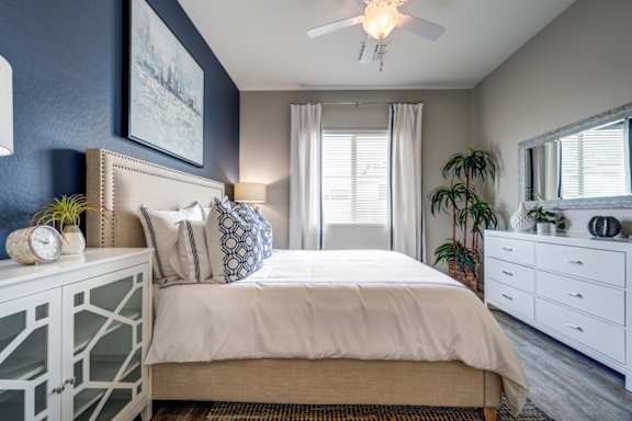 A bedroom with a bed, dresser, and mirror.