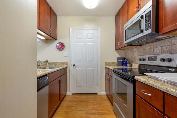 A modern kitchen with a stainless steel refrigerator and grey cabinets.