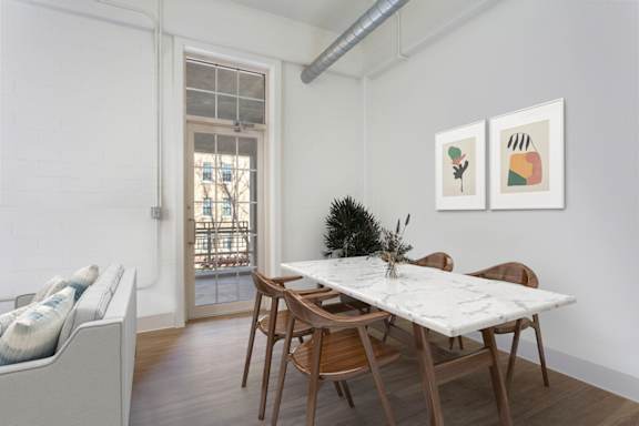 A dining room with a white table and chairs.